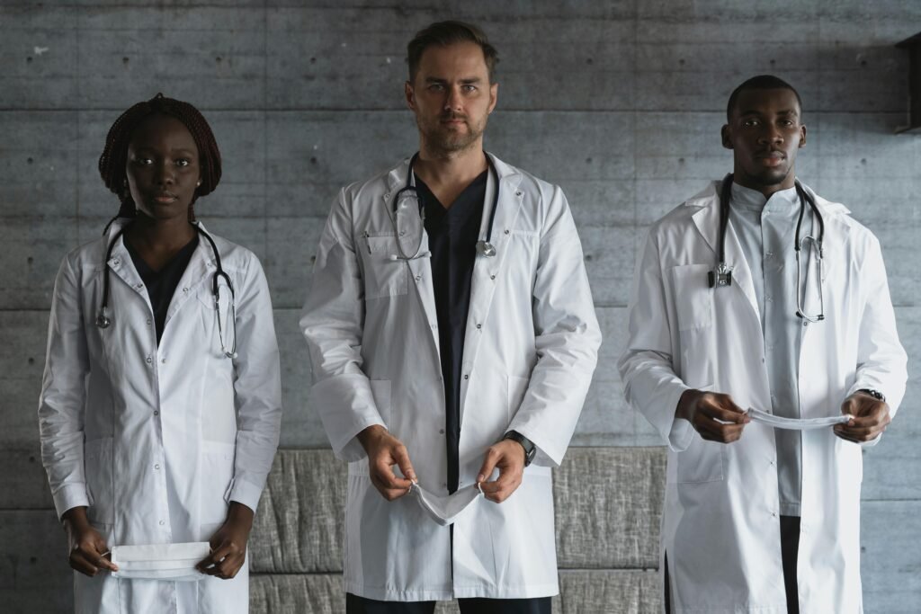 A diverse team of doctors in medical uniforms with stethoscopes in a hospital setting.